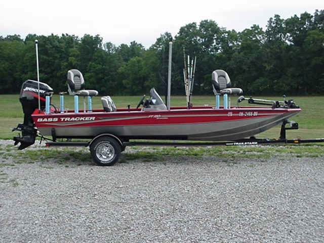 A red and silver boat parked on top of the ground.