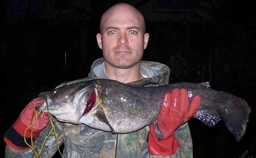 A man holding a fish in his hand.