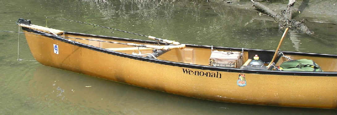 A yellow canoe with two paddles on the side.